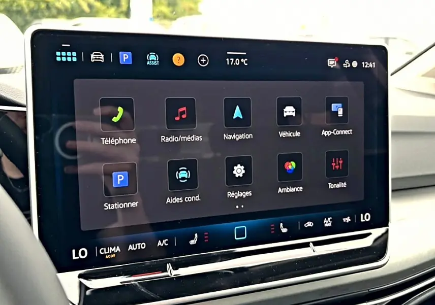 Écran tactile central de la Volkswagen Golf 2026 montrant les options de navigation et médias, intérieur clair.