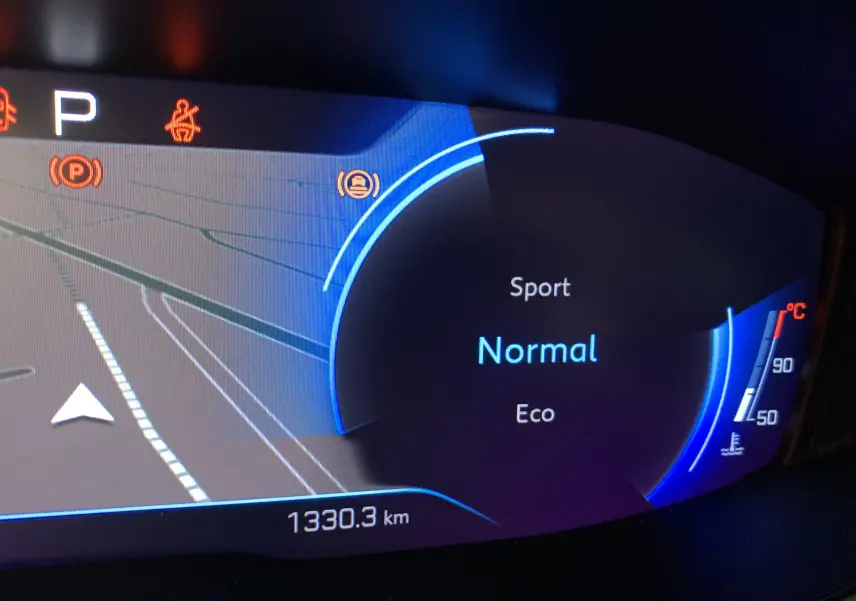 Panneau de commandes avec boutons d'assistance à la conduite et réglage des phares dans le tableau de bord d'un Peugeot 3008 bleu.