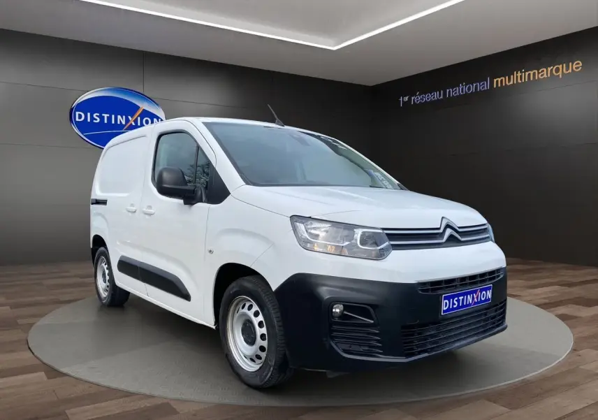 Vue 3/4 avant d'un Citroën Berlingo blanc 2019 avec pare-chocs noir et jantes acier en présentation showroom.