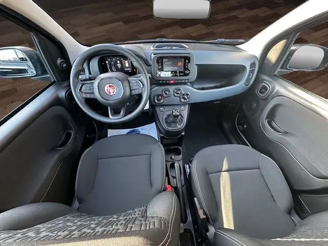 Intérieur noir de la Fiat Panda 2025 vu de face, avec tableau de bord numérique et écran tactile central.