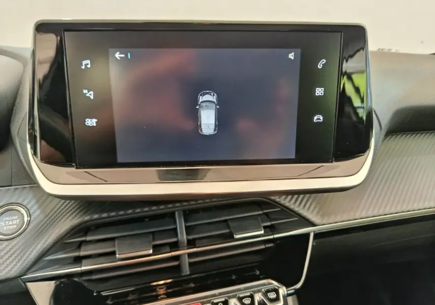 Écran tactile central affichant la vue aérienne du véhicule dans l’habitacle d’une Peugeot 208 électrique blanche.
