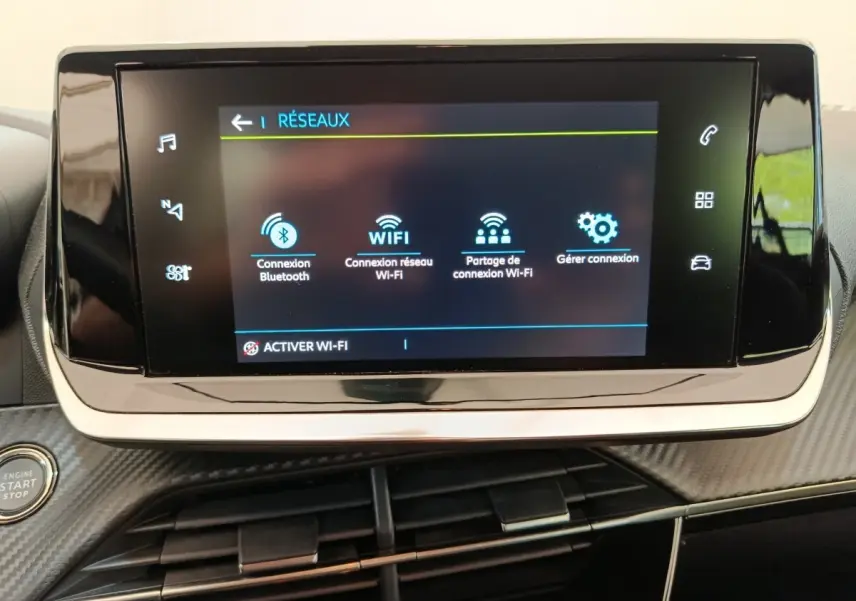 Écran tactile central affichant les options réseau dans l’habitacle d’une Peugeot 208 électrique blanche.