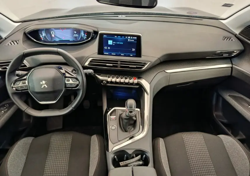 Vue intérieure avant du Peugeot 3008 gris foncé, avec tableau de bord numérique et console centrale équipée d'une boîte manuelle.