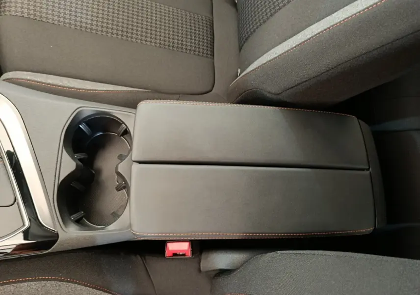 Gros plan sur l'accoudoir central noir avec surpiqûres orange et porte-gobelets du Peugeot 3008 gris foncé 2020.