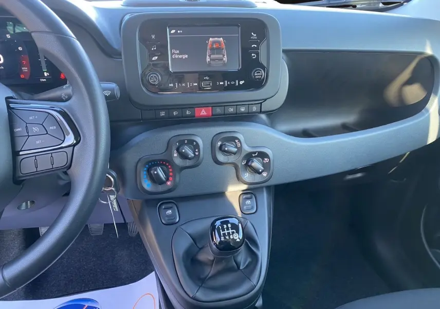 Intérieur de la Fiat Panda 2025 en noir, vue du tableau de bord avec écran multimédia et levier de vitesses manuel.
