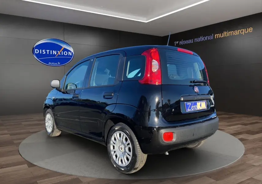Vue 3/4 arrière droite d'une Fiat Panda noire 2025 avec cinq portes, en présentation showroom.