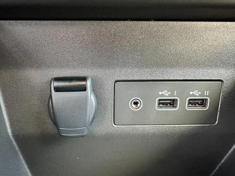 Prise 12V et double port USB intégrés dans la console intérieure noire d'une Renault Clio Gris Rafale 2025.