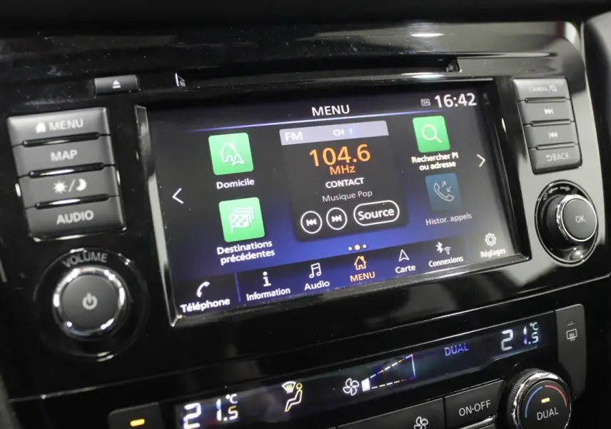 Gros plan sur l'écran tactile central et les commandes du tableau de bord du Nissan X-TRAIL gris métallisé.