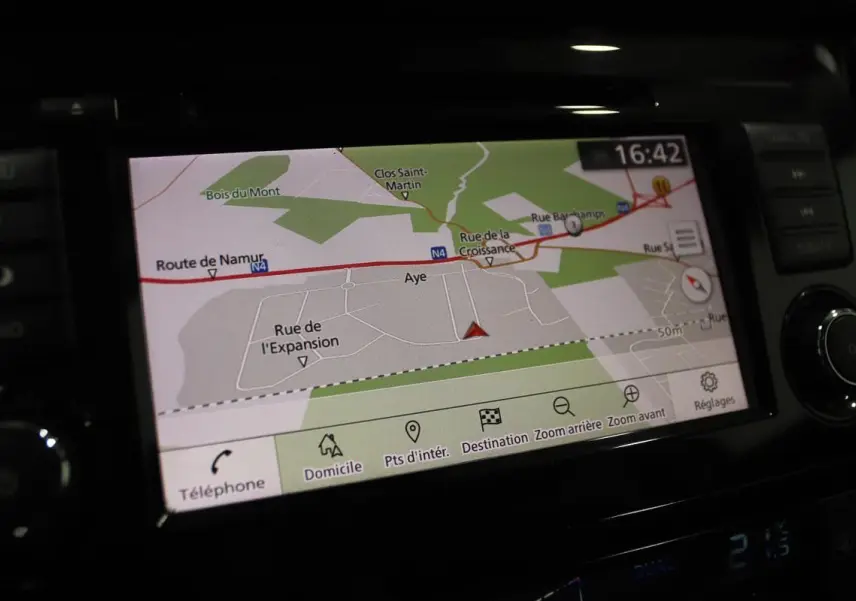 Écran GPS du Nissan X-TRAIL 2021 affichant une carte routière avec options de navigation et climatisation digitale.