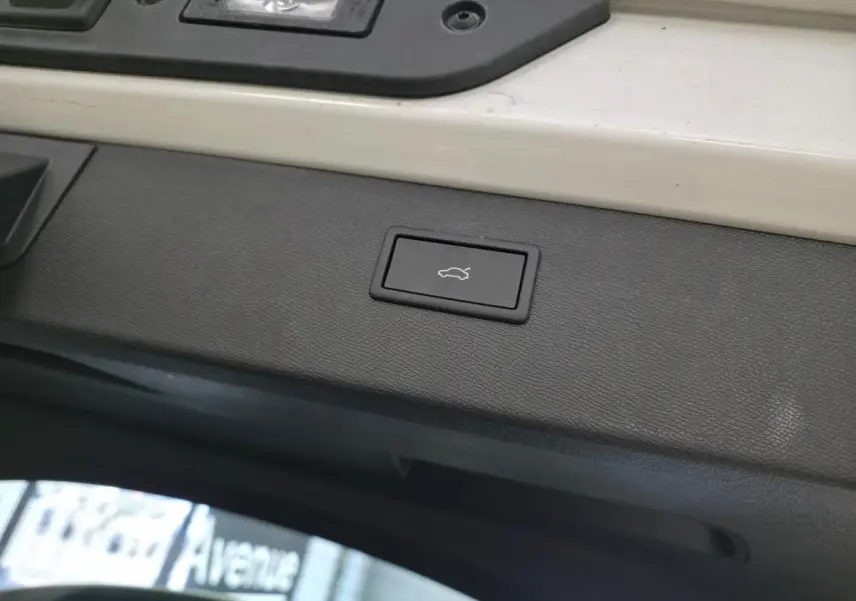 Bouton d'ouverture électrique du hayon sur la partie intérieure du coffre d'un CUPRA Formentor blanc.