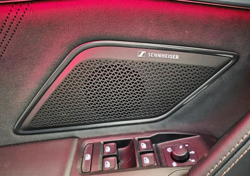 Gros plan sur la porte côté conducteur du CUPRA Formentor blanc, avec haut-parleur Sennheiser et commandes de vitres.