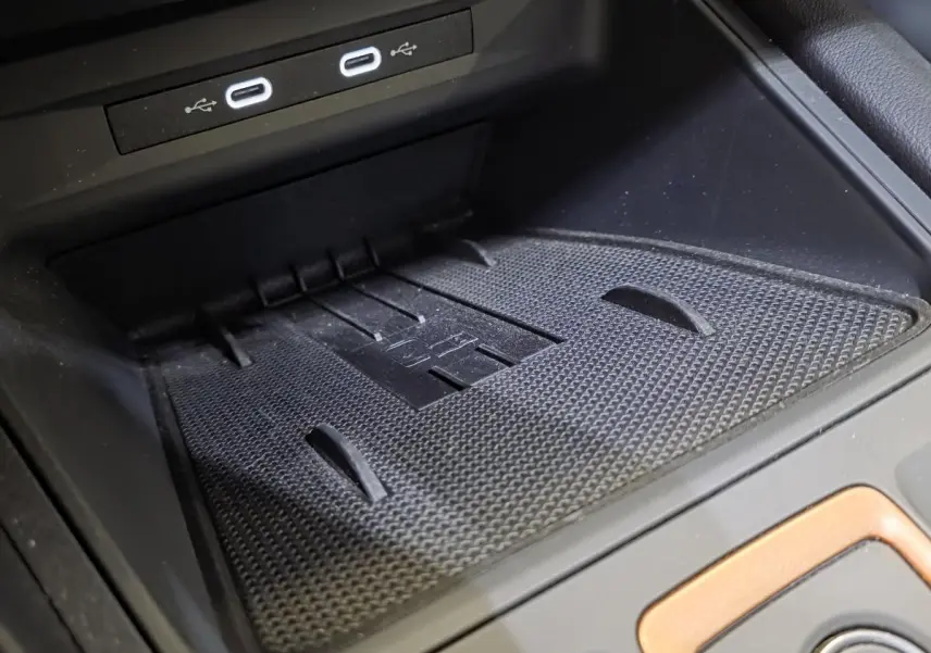 Gros plan sur la zone de charge sans fil noire avec ports USB-C dans l’habitacle du CUPRA Formentor blanc.