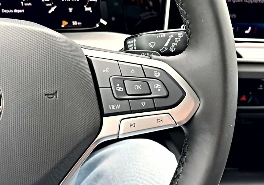 Gros plan sur le volant noir de la Volkswagen Golf 2026, mettant en valeur les commandes multifonctions côté gauche.