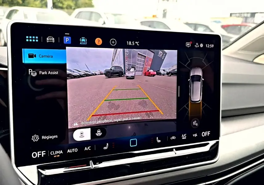 Écran tactile intérieur de la Volkswagen Golf noir 2026 montrant la caméra de recul et l'assistance au stationnement.