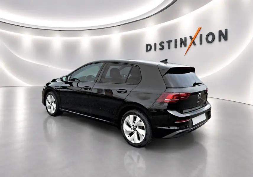Volkswagen Golf noire vue 3/4 arrière droit dans un showroom lumineux avec jantes alu 17 pouces.