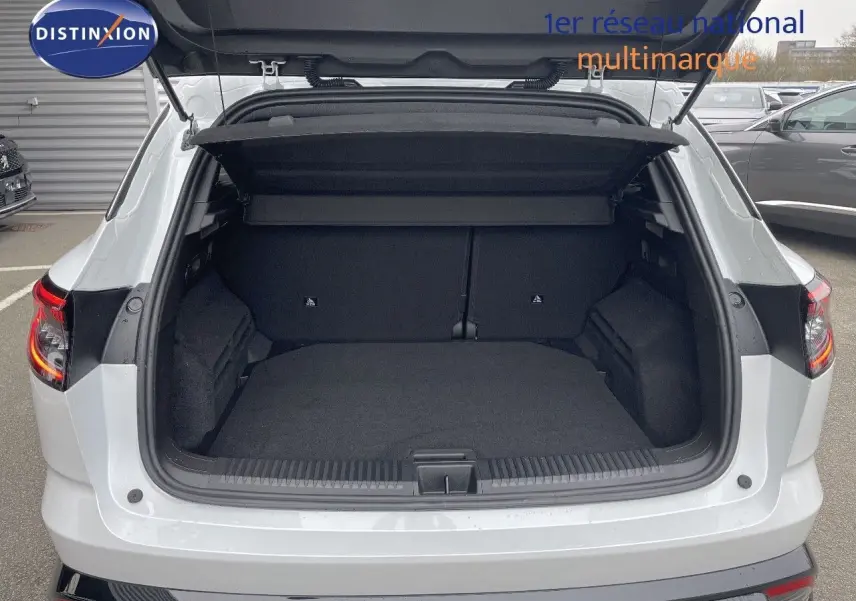 Coffre ouvert vu de l'arrière d'un Renault Austral blanc nacré, mettant en valeur l'espace de chargement vide.