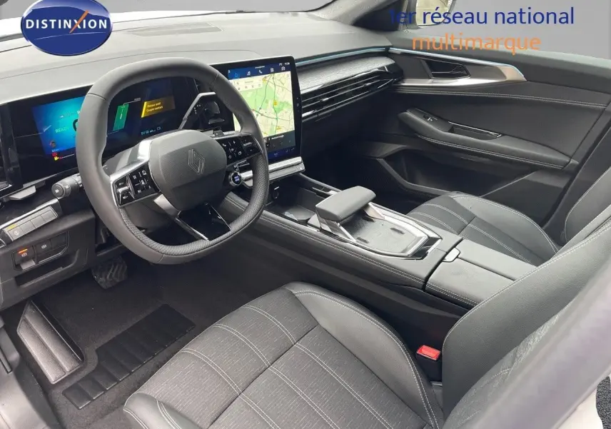 Intérieur du Renault Austral E-Tech 2024, vue côté conducteur, sièges gris noir et tableau de bord moderne avec écran tactile.