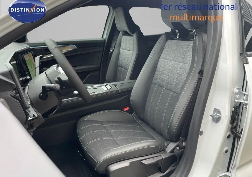 Vue intérieure côté conducteur du Renault Austral 2024 blanc nacré, sièges tissu gris et cuir noir avec surpiqûres blanches.