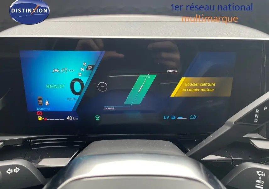 Tableau de bord numérique du Renault Austral E-Tech blanc nacré, affichant la vitesse et alertes, vue frontale intérieure.