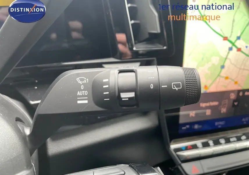 Gros plan sur la commande d'essuie-glace à gauche du volant dans l'habitacle du Renault Austral blanc nacré 2024.