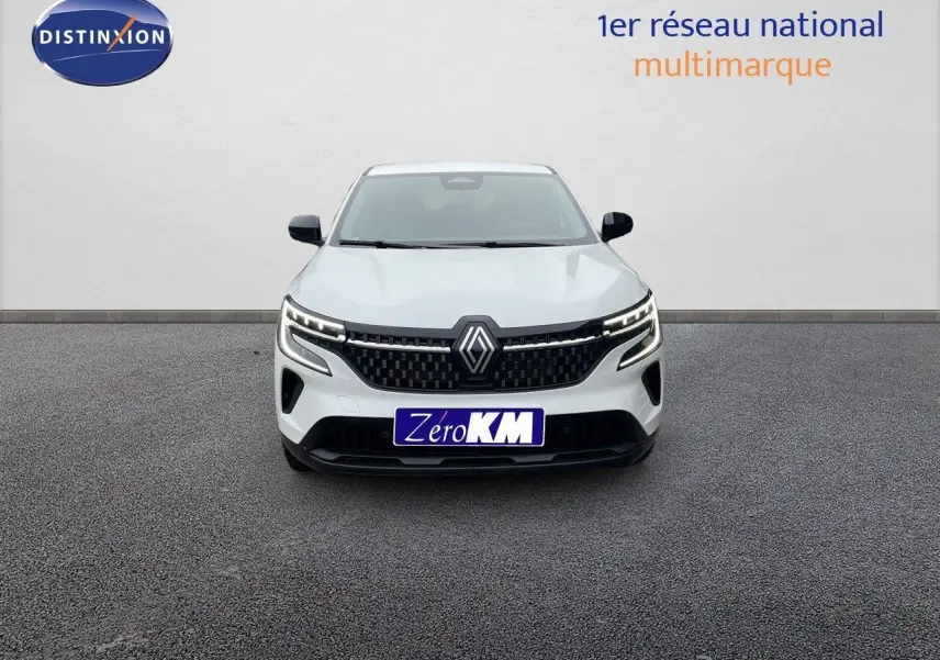 Vue frontale d'un Renault Austral blanc nacré avec calandre noire et feux LED allumés sur fond neutre.