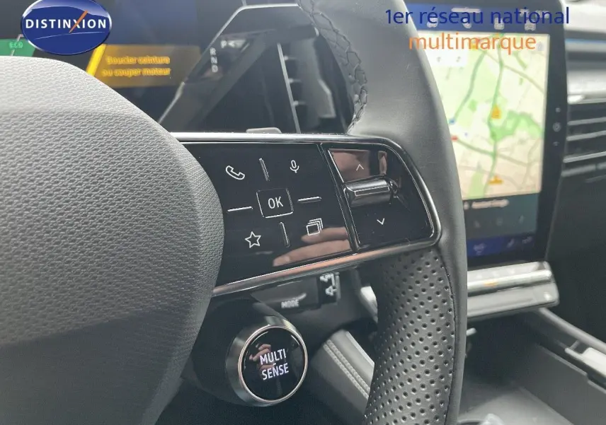 Gros plan sur le volant perforé du Renault Austral blanc nacré, avec commandes tactiles et bouton Multi Sense visible.