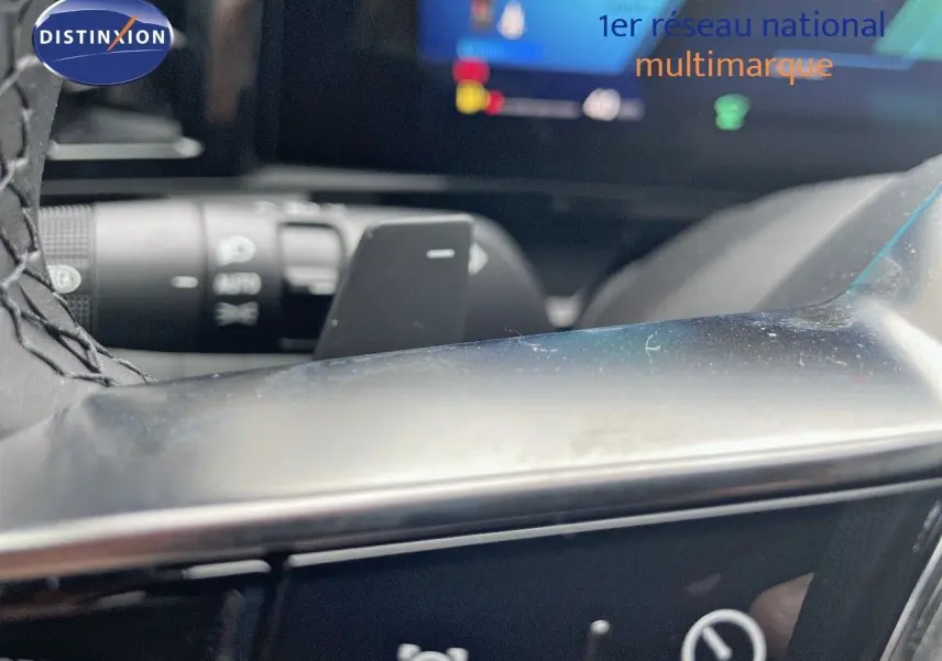 Gros plan sur la commande au volant du Renault Austral blanc nacré, mettant en valeur les boutons multifonctions.