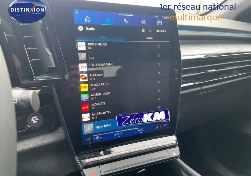 Écran tactile central affichant les options radio dans l'habitacle du Renault Austral blanc nacré 2024.