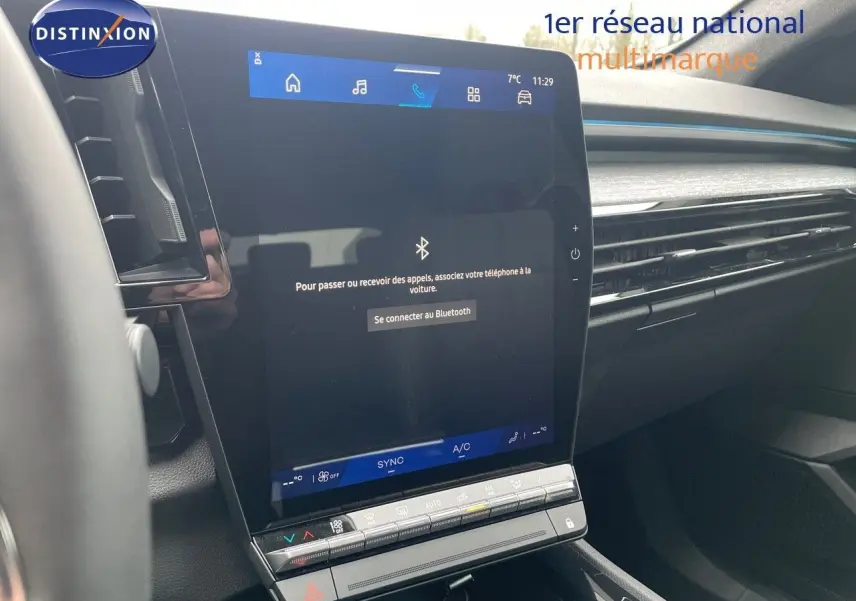 Vue rapprochée de l'écran tactile central du Renault Austral blanc nacré 2024 avec commandes climatisation intégrées.