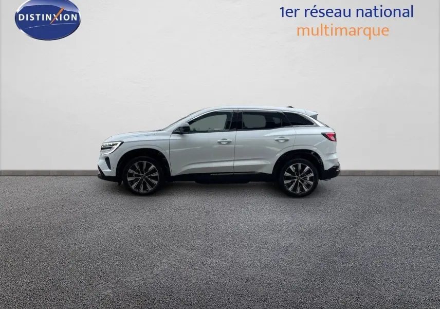 Profil côté gauche d'un Renault Austral blanc nacré 2024 hybride avec jantes bi-ton et lignes épurées.