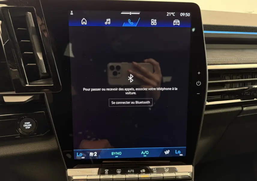Écran tactile central allumé avec interface Bluetooth dans l'habitacle noir du Renault Espace gris foncé, vue de face rapprochée.