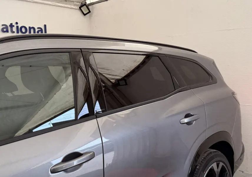 Vue latérale côté droit du Renault Espace gris foncé esprit Alpine 7 places avec vitres teintées et poignées intégrées.