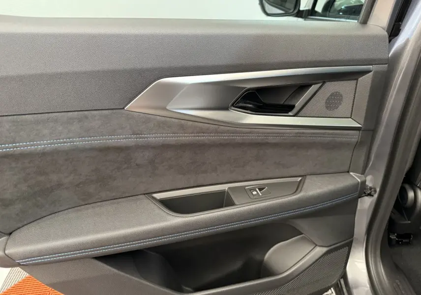 Détail de la porte intérieure côté gauche du Renault Espace esprit Alpine 7PL gris foncé avec surpiqûres bleues.