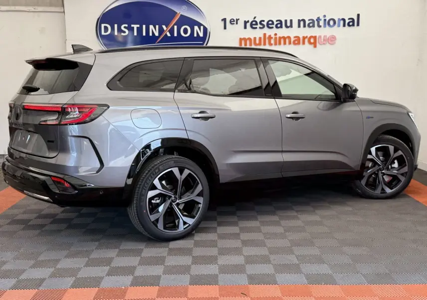 Profil droit du Renault Espace esprit Alpine gris foncé avec jantes noires et toit vitré en intérieur showroom.