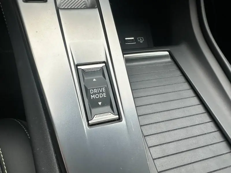 Gros plan sur le bouton Drive Mode et la console centrale argentée de la Peugeot 308 SW 2023 essence.