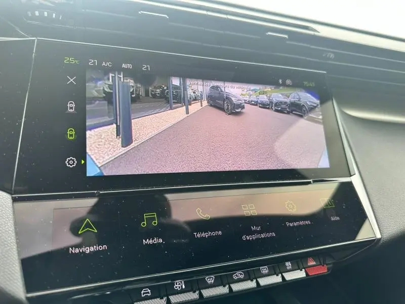 Écran tactile intérieur montrant la caméra de recul avec vue arrière sur un véhicule noir en stationnement.