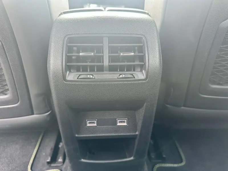 Vue rapprochée des aérateurs arrière noirs et des deux ports USB du Peugeot 308 SW 2023 côté arrière des sièges avant.