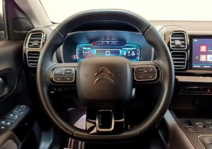 Vue intérieure centrée sur le volant cuir noir multifonctions du Citroën C5 Aircross 2020 avec tableau de bord digital lumineux.