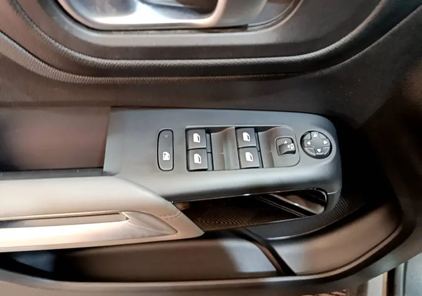 Gros plan sur la commande des vitres électriques côté conducteur du Citroën C5 Aircross gris foncé, intérieur noir.