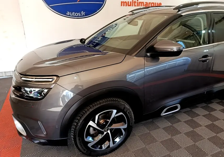 Vue 3/4 avant droit d’un Citroën C5 Aircross gris foncé avec jantes alliage et rétroviseurs électriques chromés.