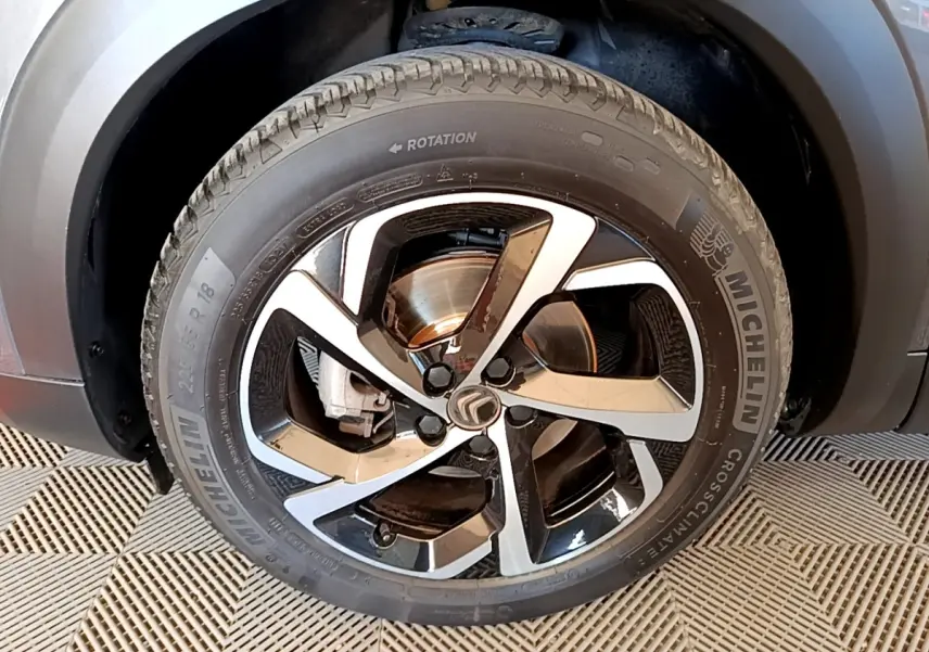 Gros plan sur la roue avant droite du Citroën C5 Aircross gris foncé, jante alliage bicolore et pneu Michelin.