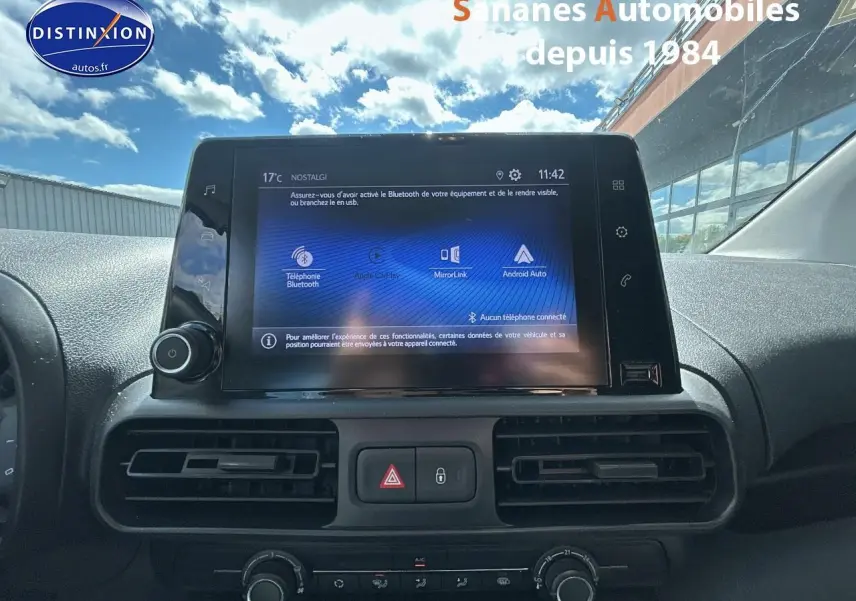 Vue rapprochée de l’écran tactile central du Toyota Proace City 2023 avec commandes de climatisation et tableau de bord noir.