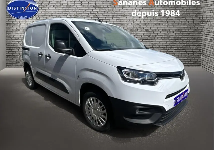 Toyota Proace City blanc vue 3/4 avant droit avec coques de rétroviseurs noires et porte latérale tôlée.