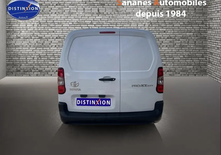 Vue arrière d'un Toyota Proace City blanc 2023 avec portes battantes et logo Toyota visible.