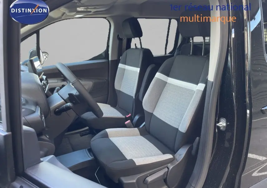 Vue intérieure côté gauche du Citroën Berlingo noir Perla Nera, montrant les sièges avant en tissu bicolore gris et noir.