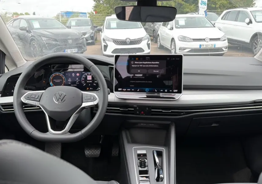 Vue intérieure avant de la Volkswagen Golf noire 2026, avec tableau de bord digital et grand écran central tactile.
