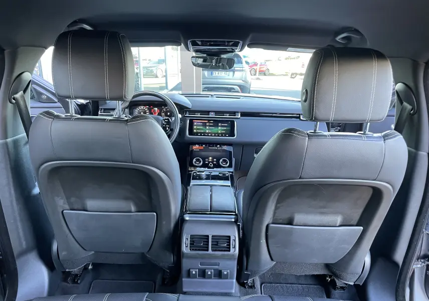 Vue arrière de l'intérieur du Range Rover Velar D240 S R-Dynamic 2018 en cuir noir avec tableau de bord digital.