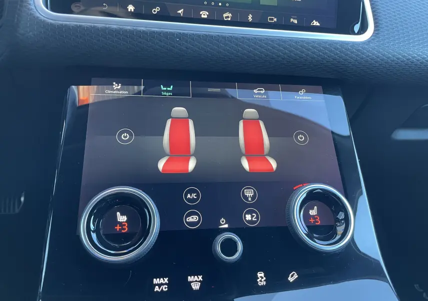 Gros plan sur l'écran tactile central du Range Rover Velar 2018 montrant le réglage des sièges chauffants en rouge et gris.
