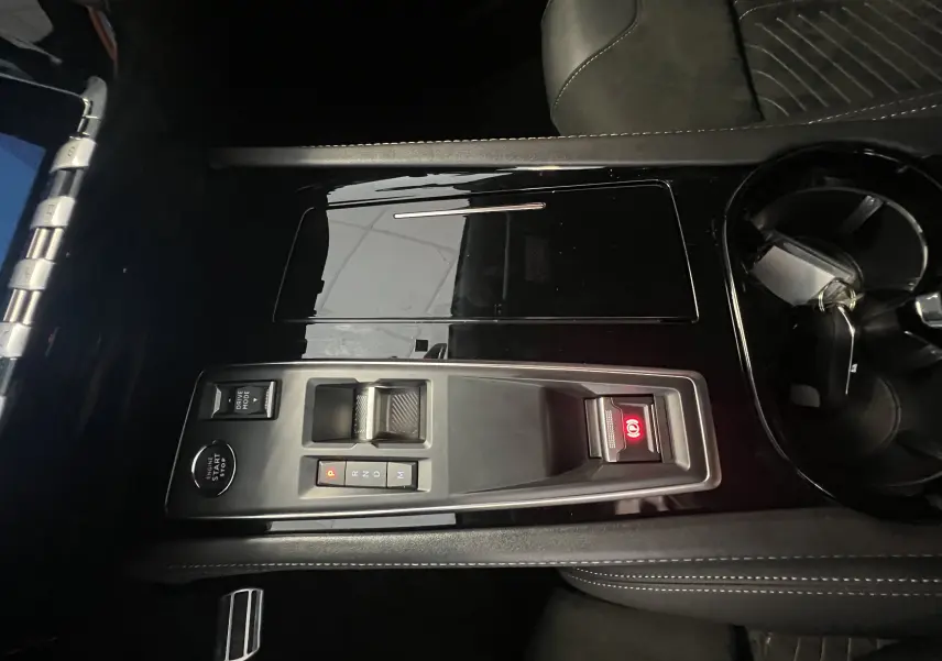 Vue rapprochée de la console centrale noire brillante du Peugeot 508 SW 1.5 HDI 130 GT avec commandes de boîte auto et frein électronique.