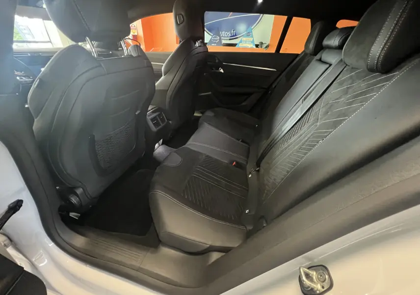 Vue intérieure côté droit sur les sièges arrière en cuir noir avec surpiqûres du Peugeot 508 SW blanc 2024